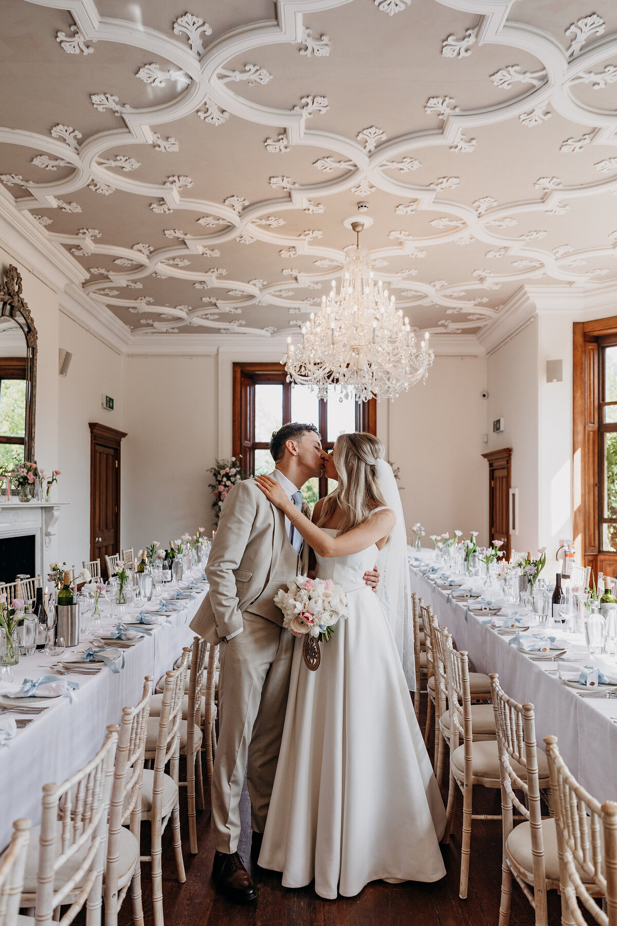 Bride and groom kissing in dining room at Thicket Priory York