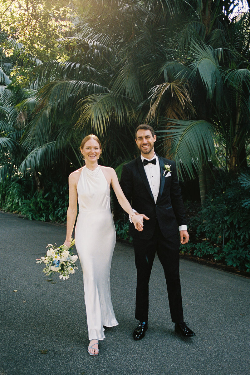 Couple at their micro-wedding in Fitzroy Gardens, Melbourne, captured on 35mm film in a relaxed, natural, journalistic style