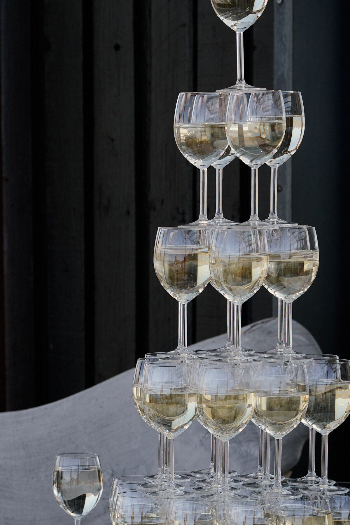 A close shot of a champagne tower in front of a black wall