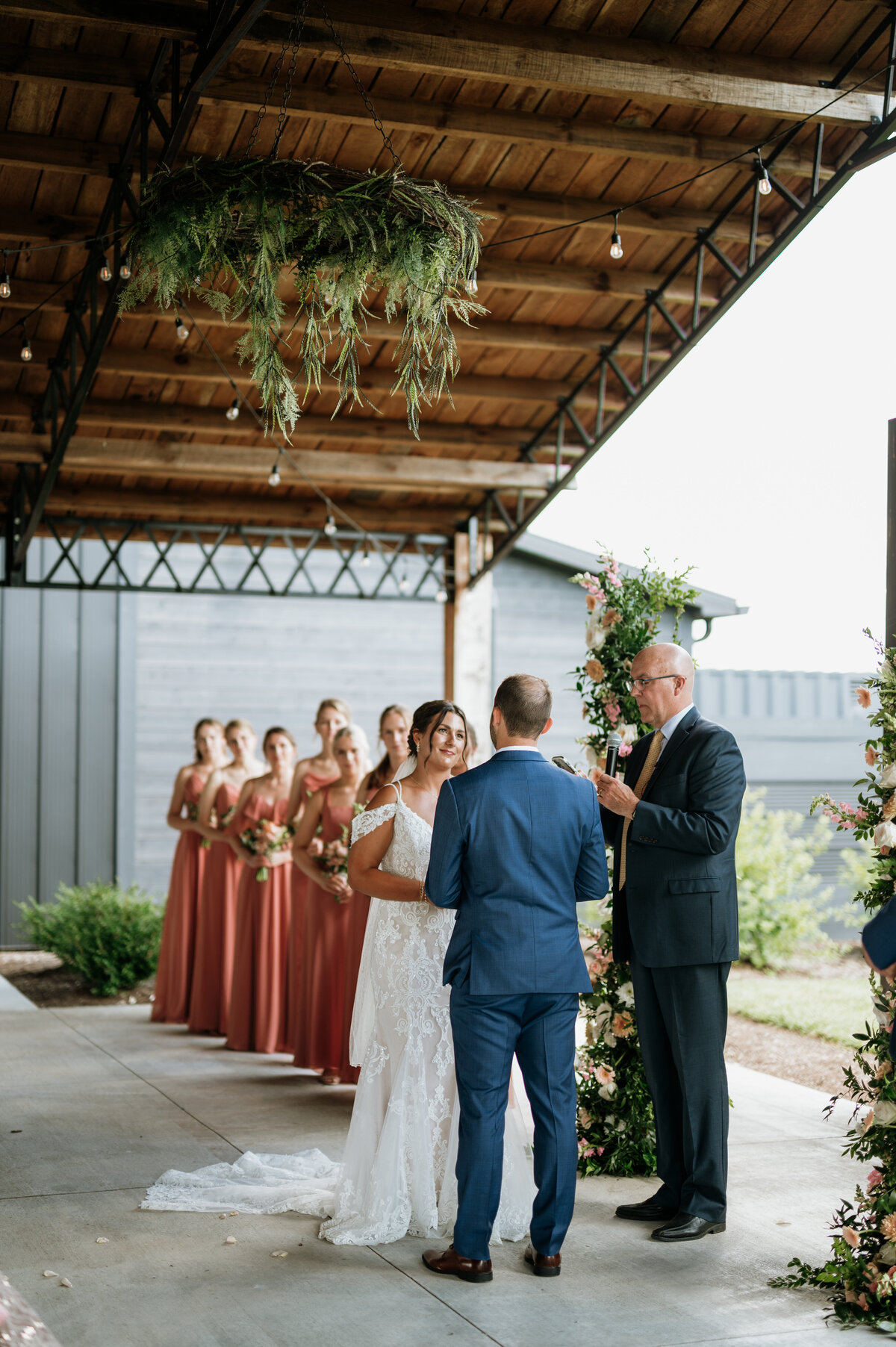 Wedding party standing under wooden pergola