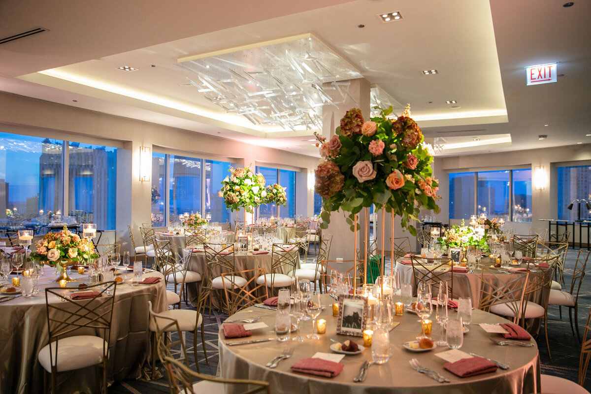 A large room with tables and chairs set up for a wedding reception.