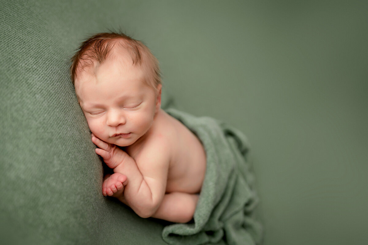 baby on green backdrop during studio photo shoot