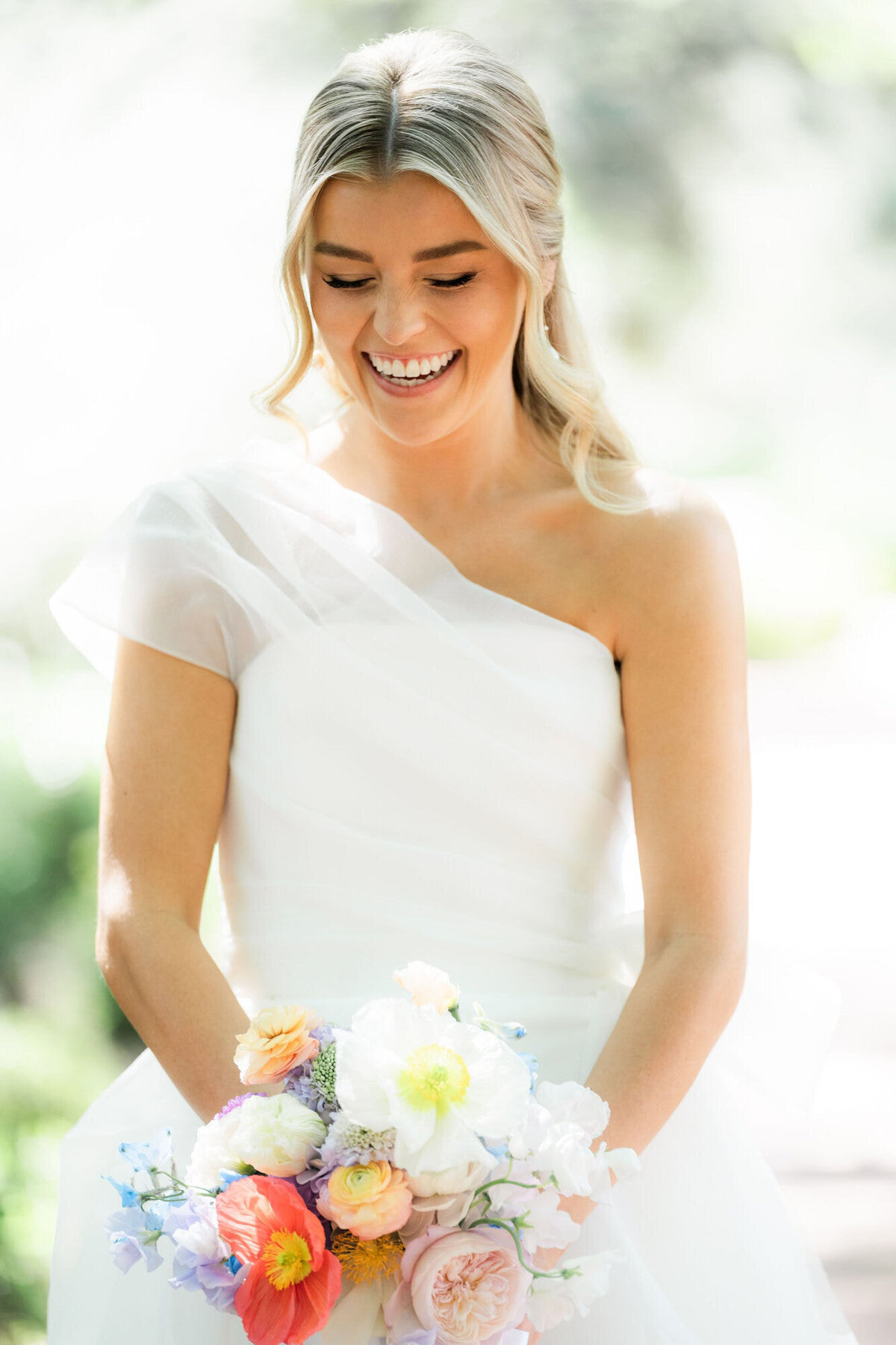 Bride laughing looking down at her bouquet at El Chorro Scottsdale.