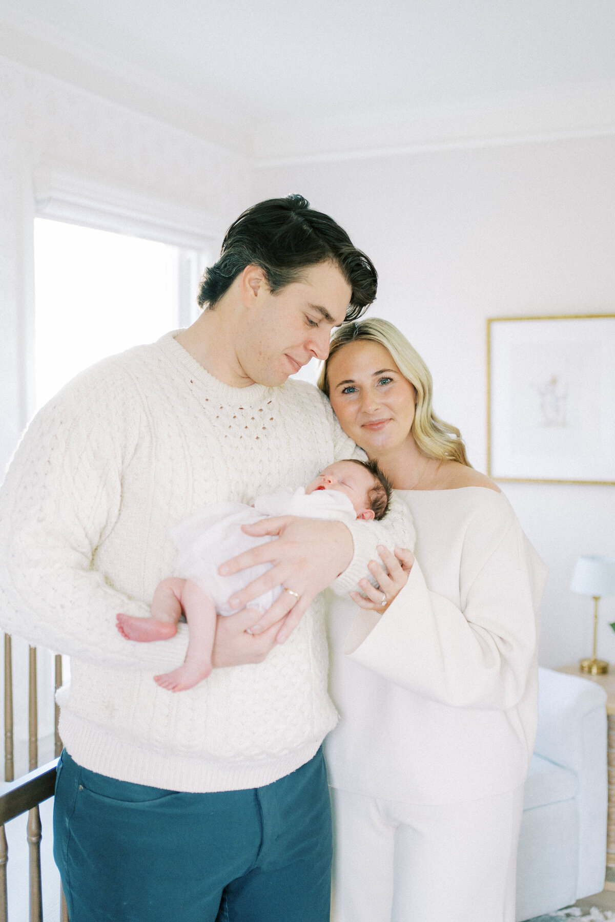 mom smiling with husband and newborn son
