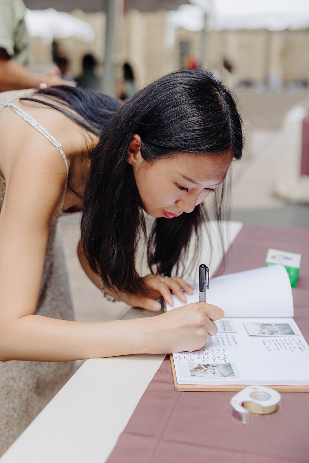 Guest writing in guest book at Cornell University wedding