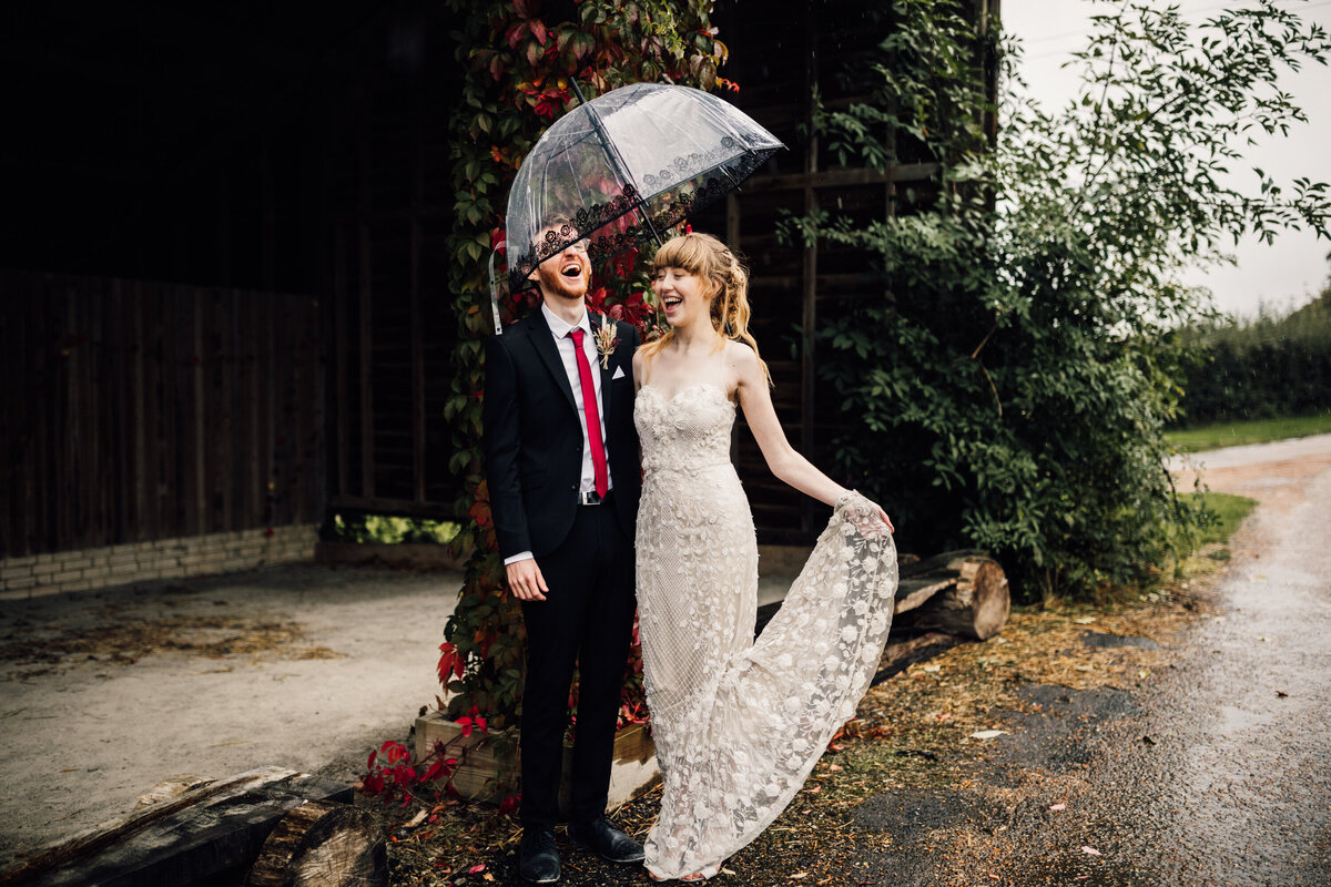 Bride and Groom laughing under umbrella in south London streets