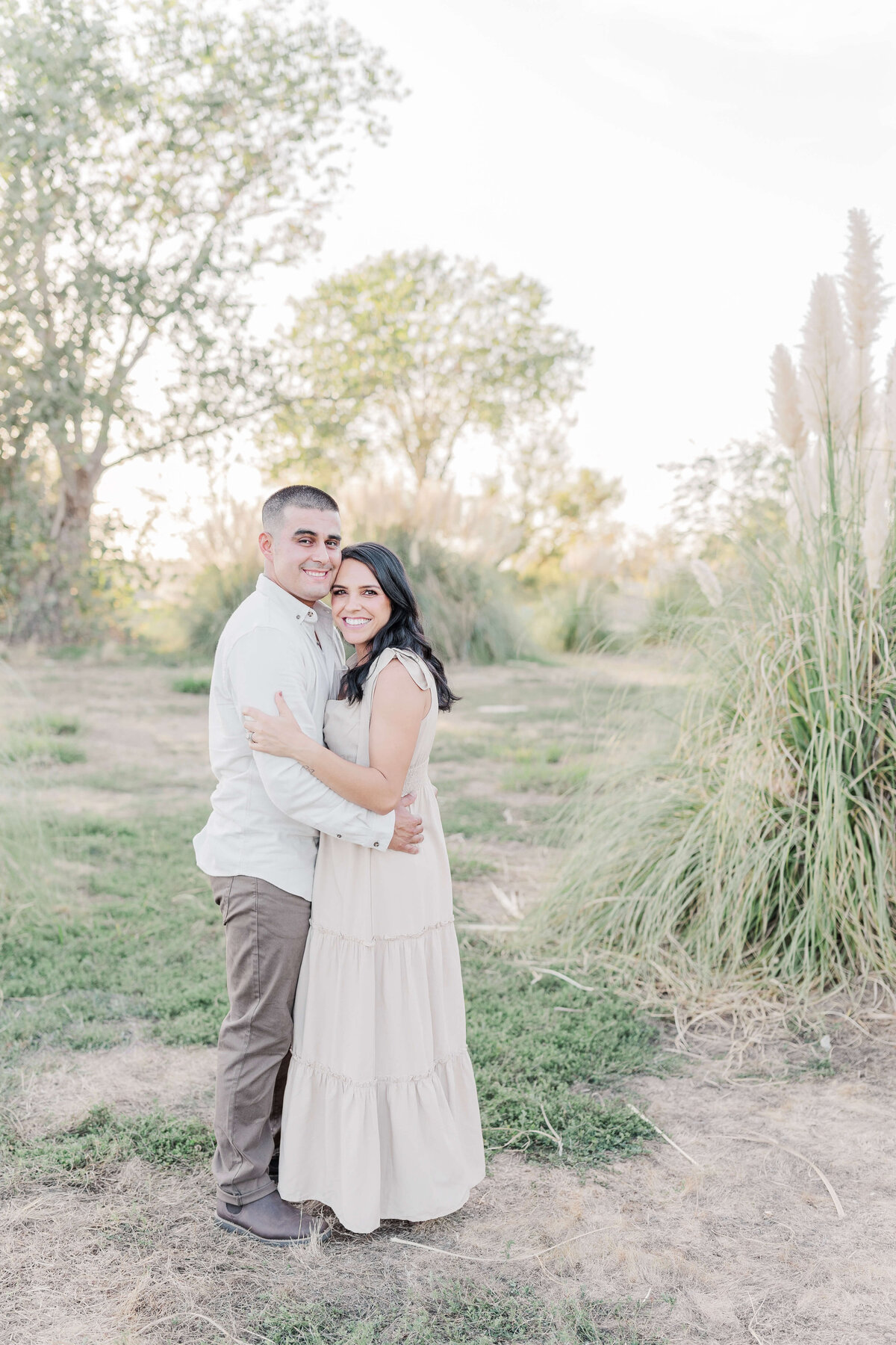 A gorgeous couple hugging in Sacramento park during family photography by Caroline Bendel