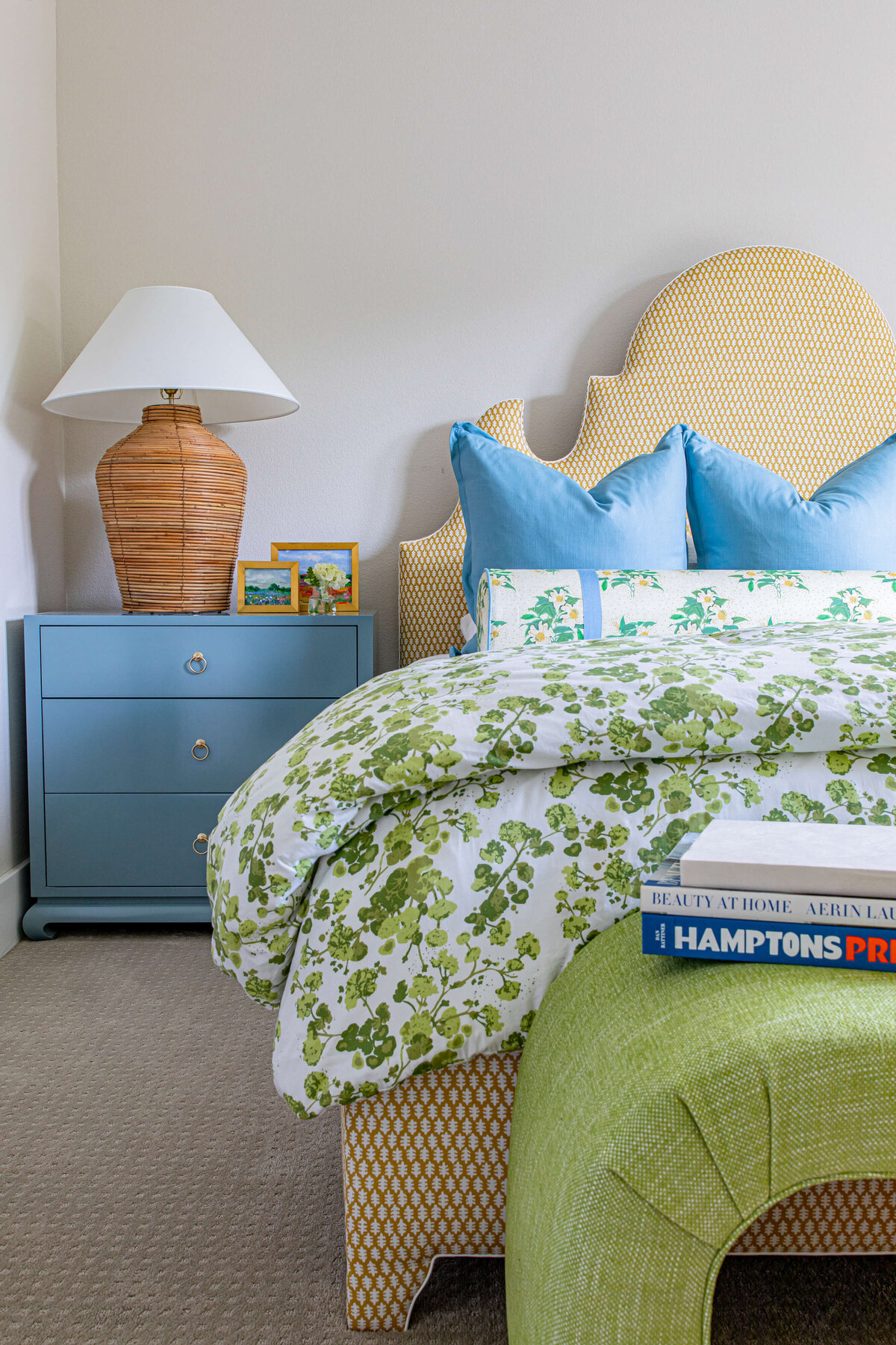 oyster creek studios aryns home blue pillow and green floral bedpsread on tan bed in bedroom