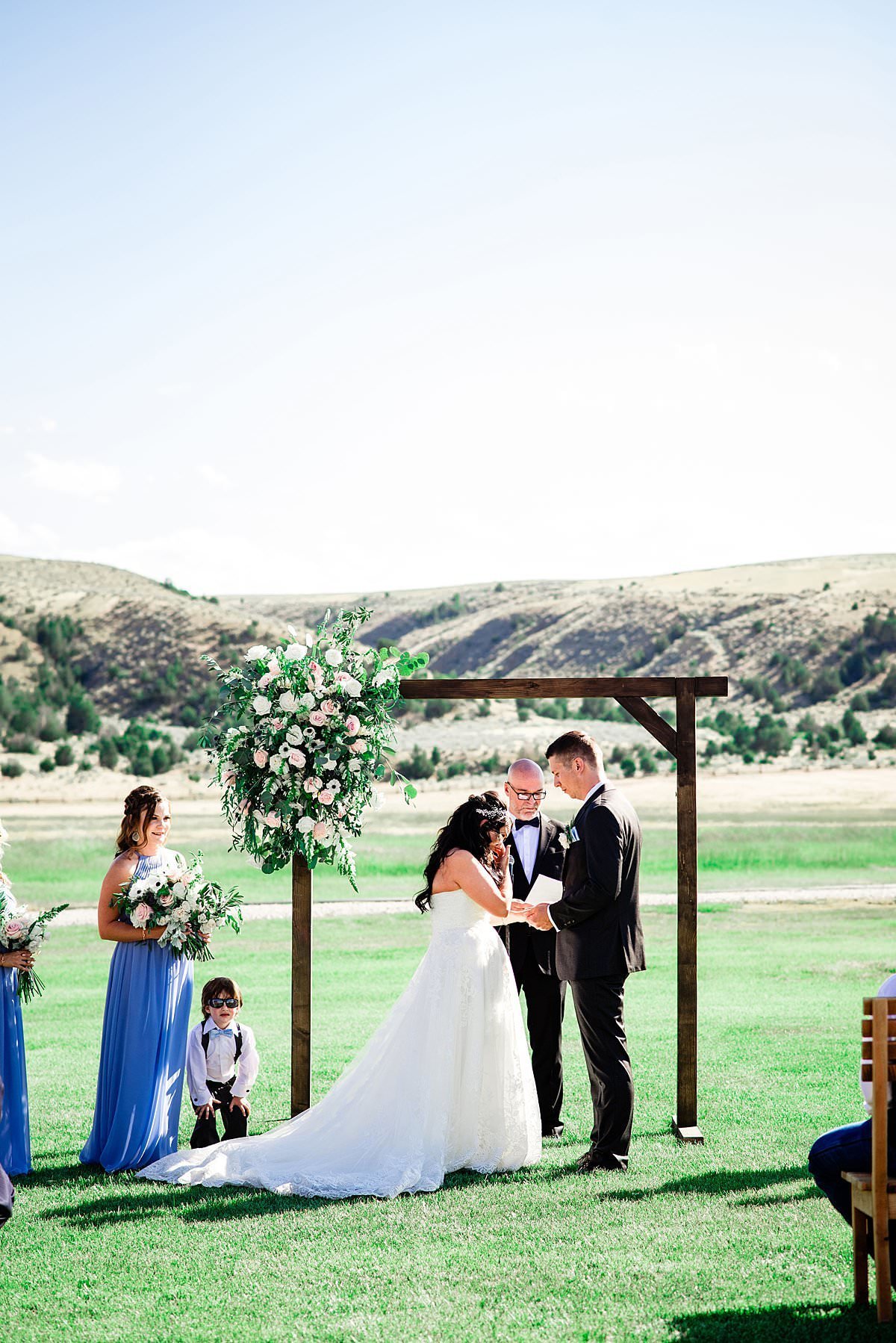 Bride becomes emotional during ceremony outside of Headwaters Ranch with Montana mountains in the background