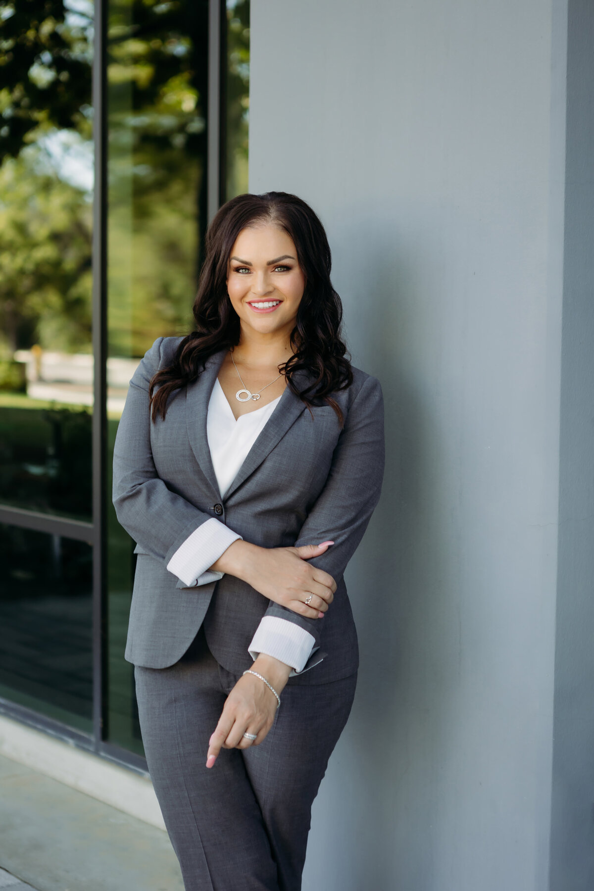 Outdoor headshot of a woman in a grey suit