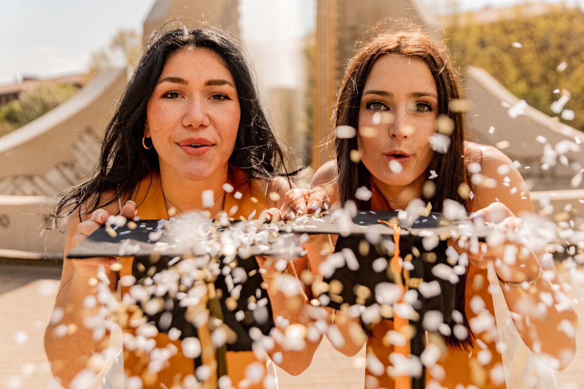 Girls with graduation caps and confetti