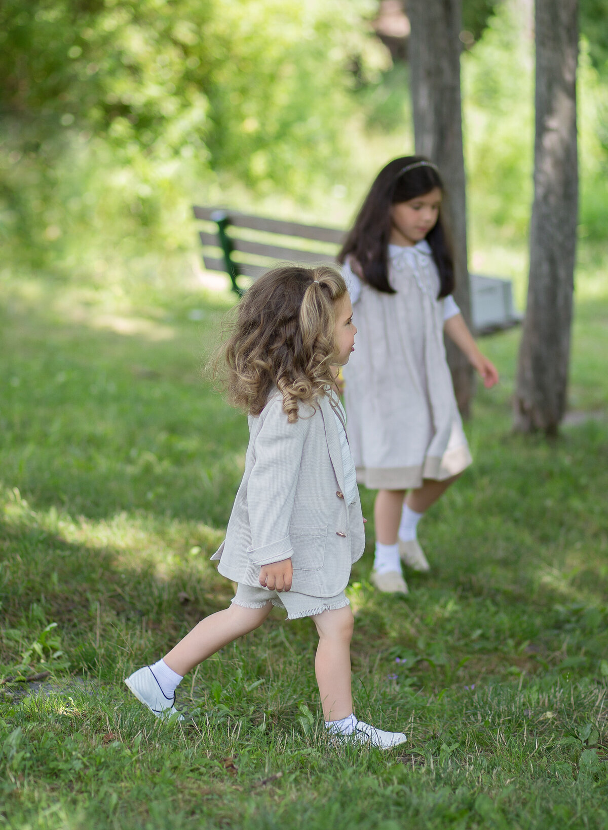 Brother and sister captured walking through a brooklyn park for a family photoshoot to commemorate his upsherin. Captured by Chaya Bornstein, Brooklyn Family Photographer