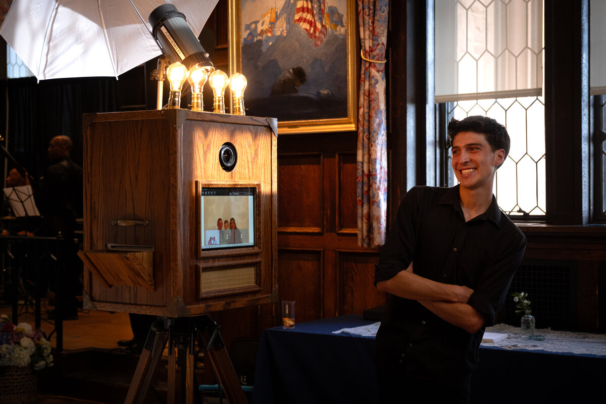 Wooden photo booth with Edison bulbs glowing during an indoor event setup.