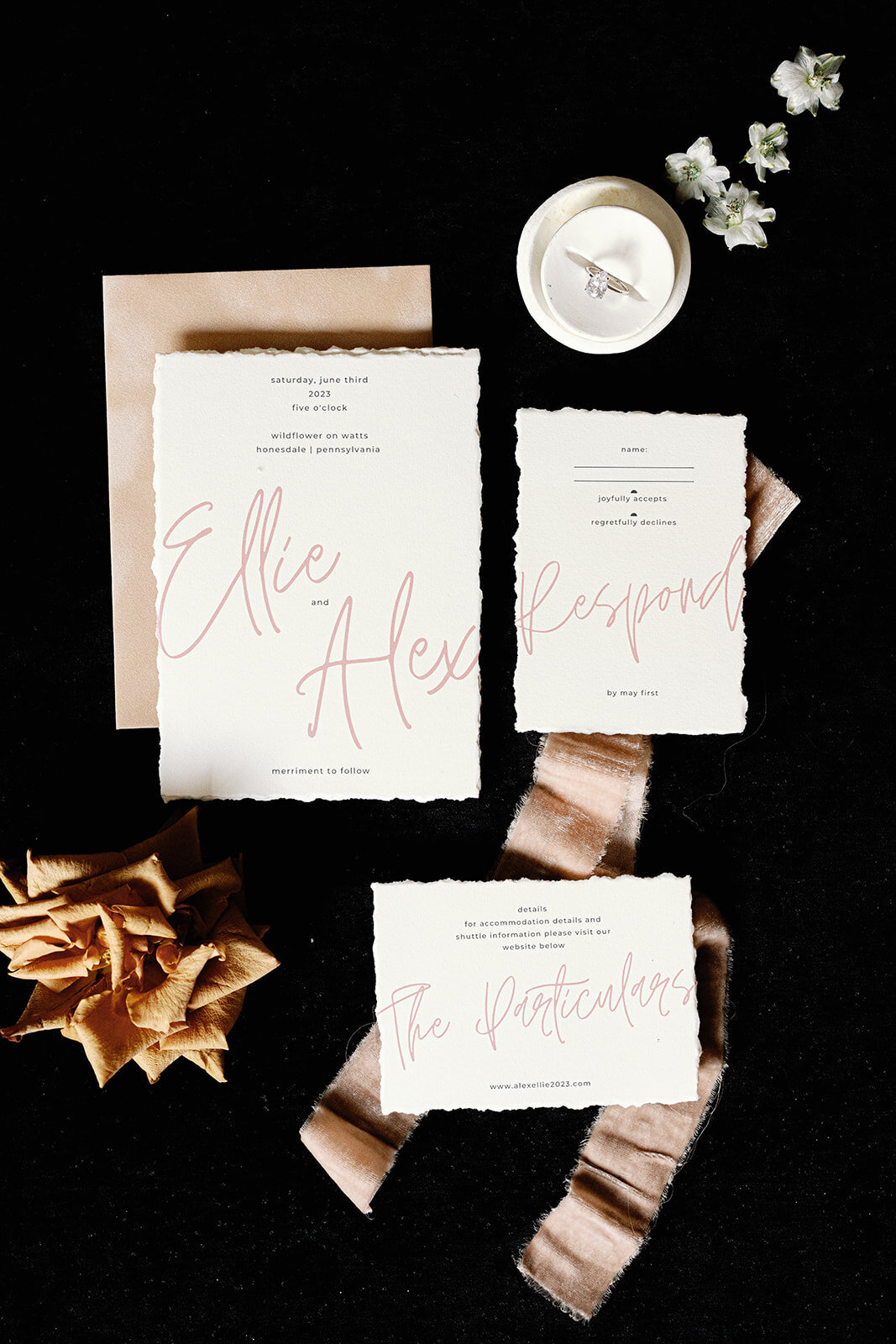 Detail photo of wedding stationery and rings on a black background