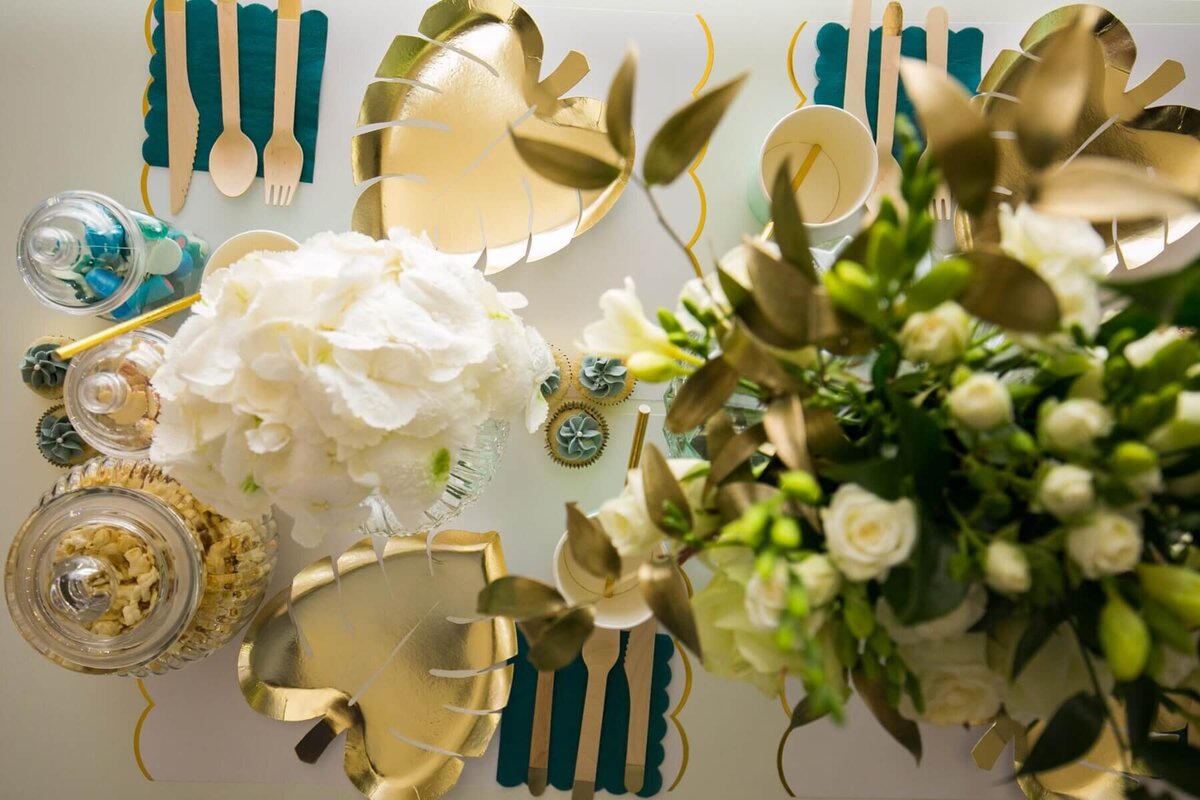 Gold and white table setting with white and green flowers