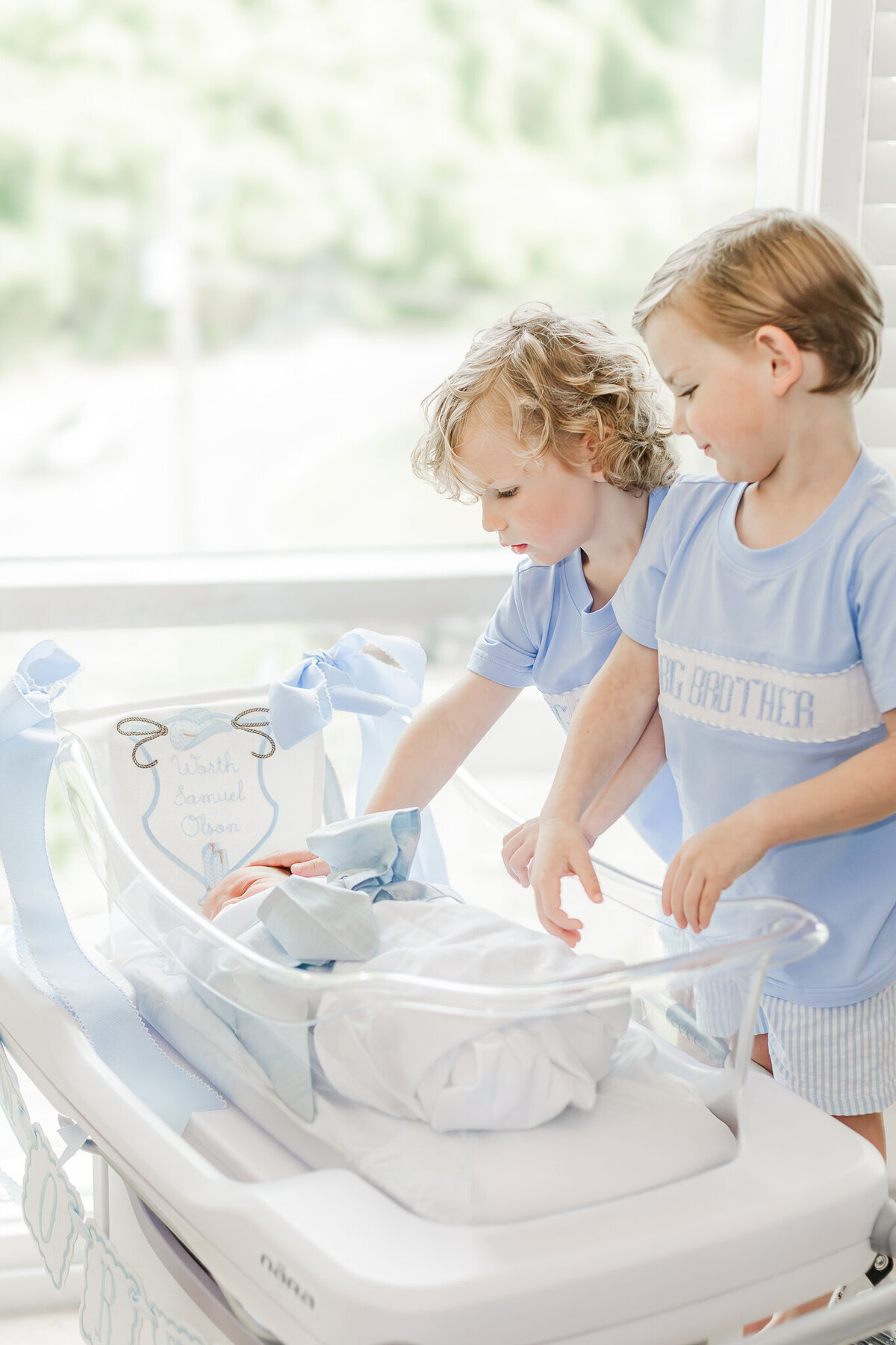 Big brothers looking down at newborn brother after delivery at Brookwood Hospital