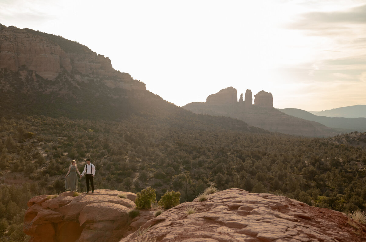 Couple standing against red rock backdrop during Sedona engagement session
