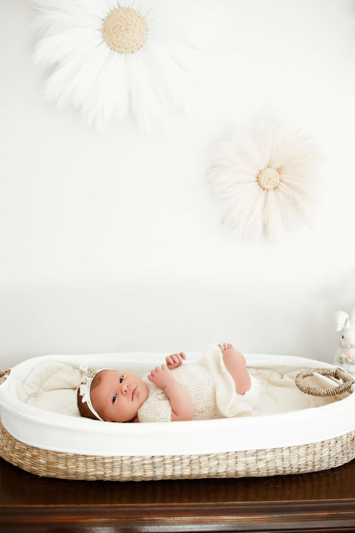 baby girl during her in home newborn session laying on her changing pad 