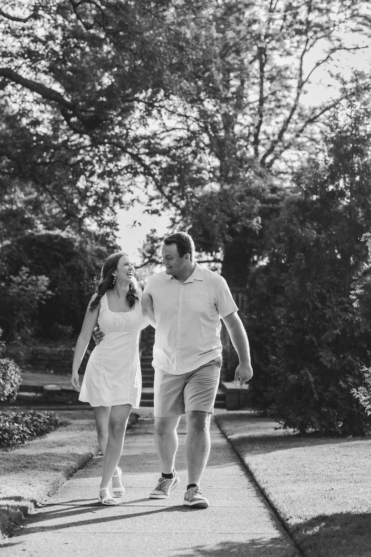 Engaged couple walking down a path at Francis Park in Lansing Michigan. 
