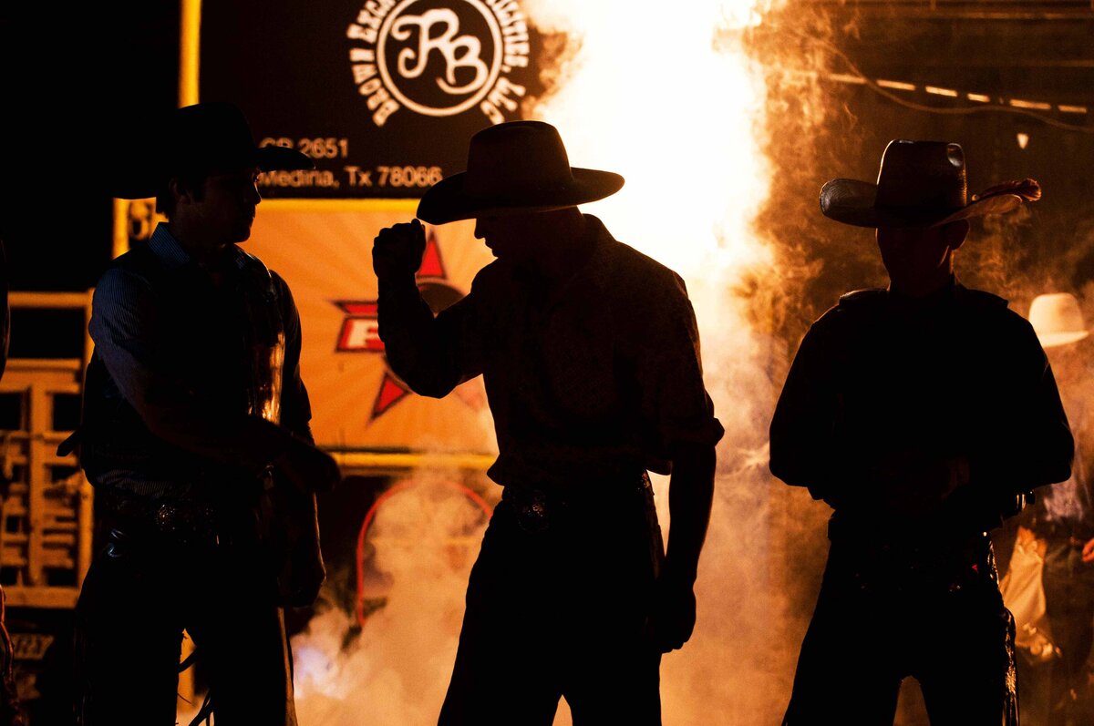 Rodeo cowboys silhouetted with fire behind them  in San Antonio TX