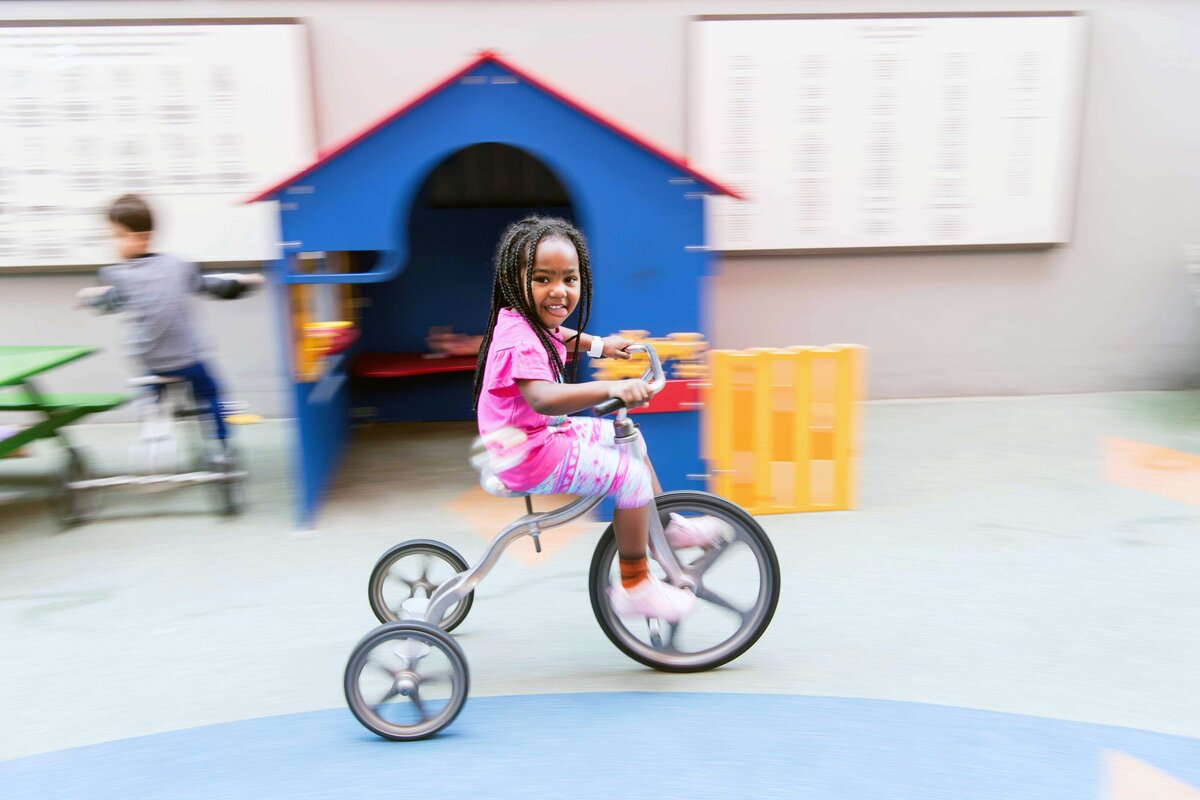 A child rides a tricycle at Father Joe's Villages