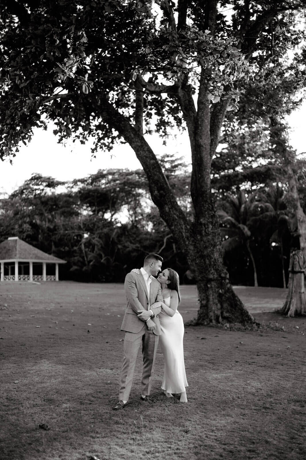 Black and white photo of the engaged couple standing close and looking at each other in the garden on Round Hill Hotel, Jamaica.