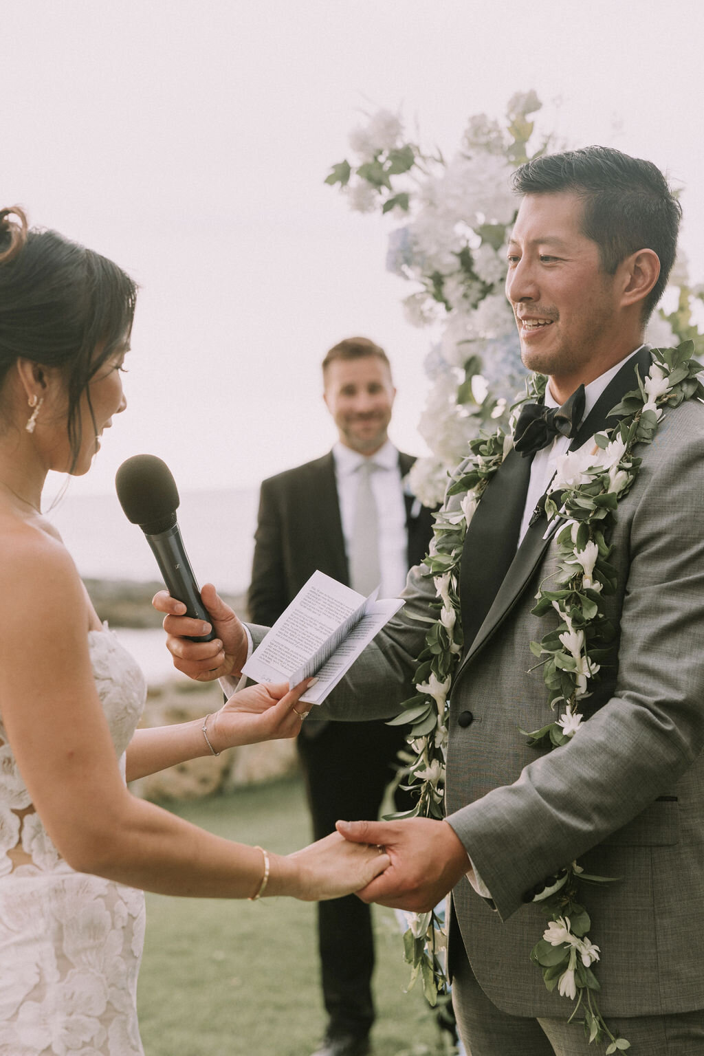 bride and groom reading vows to one another at lanikuhonua