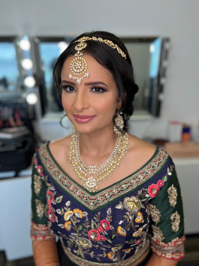 Indian bride in Ottawa adorned with a classic makeup look, including flawless skin and a pink lip for subtle beauty.