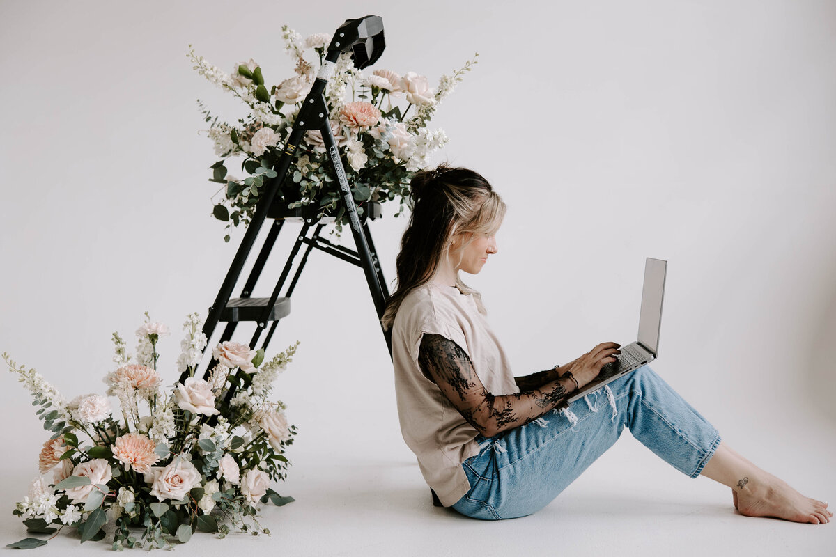 woman sits with a laptop in her lap