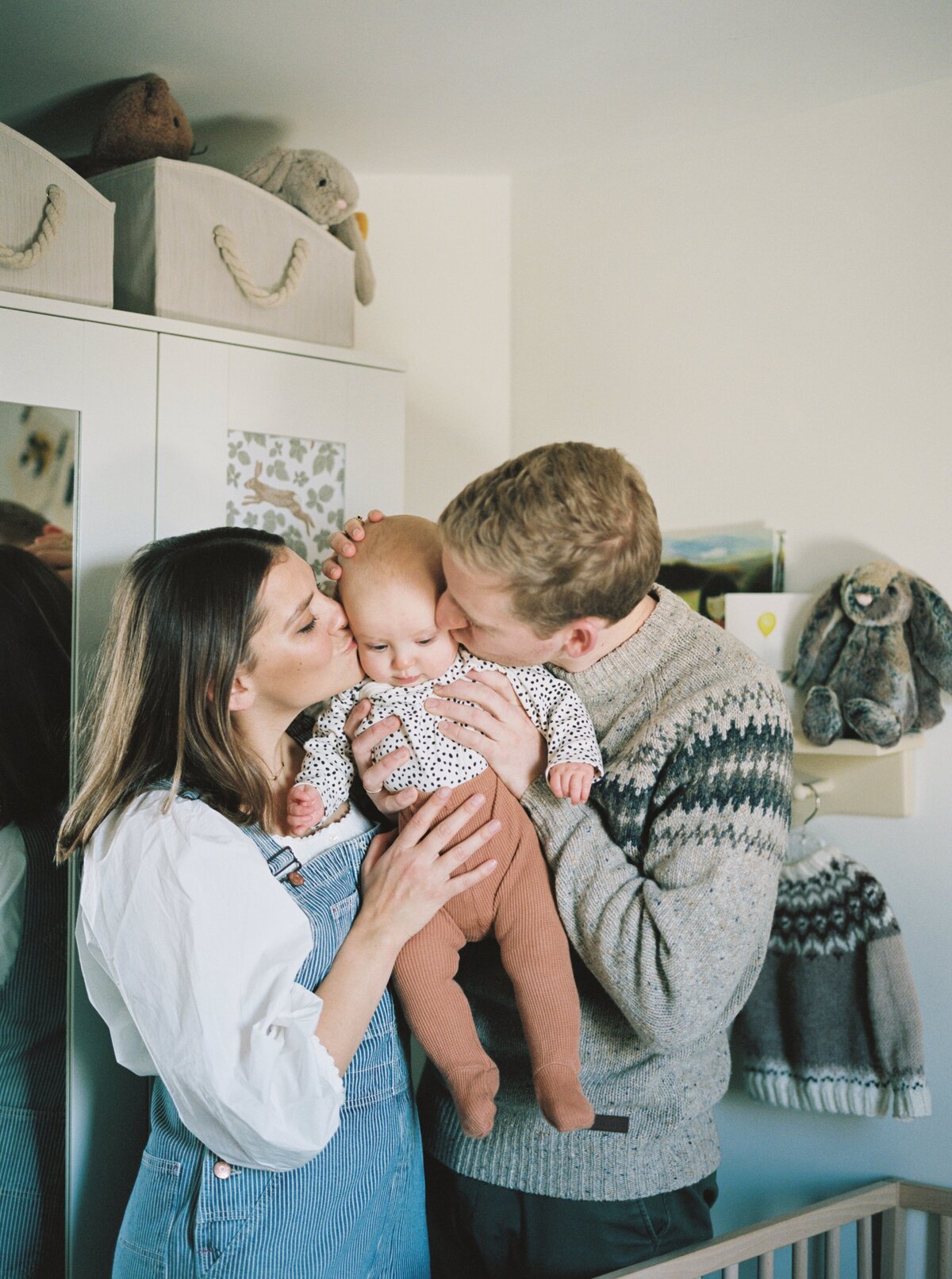 parents-kissing-baby-on-both-cheeks