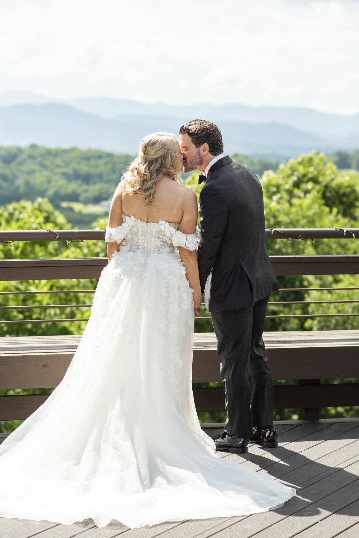 Couple kissing with mountain view at Crest Pavilion Asheville wedding
