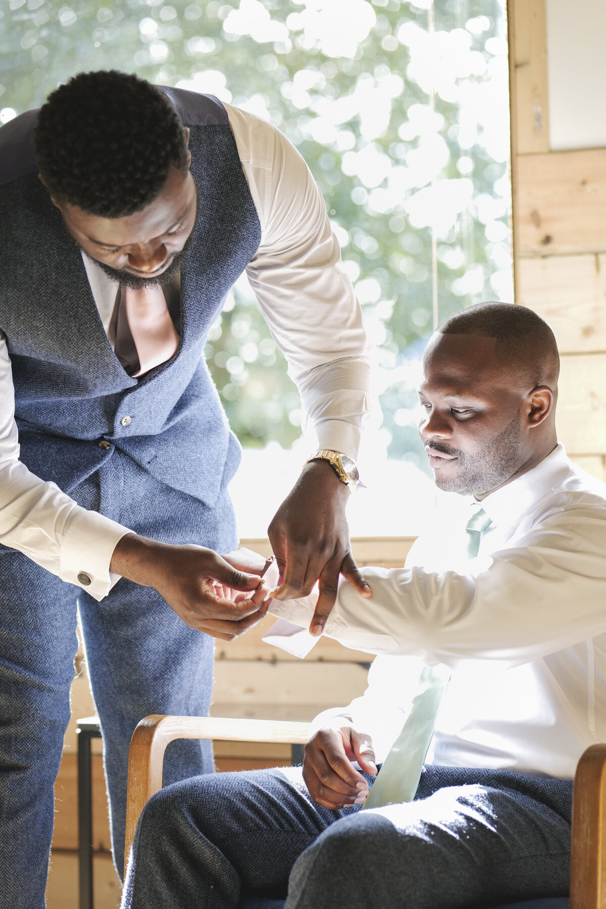 Dexter's groomsmen helping with cufflinks
