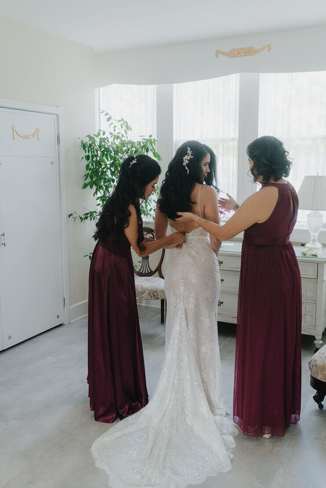 Bride being helped by two bridesmaids