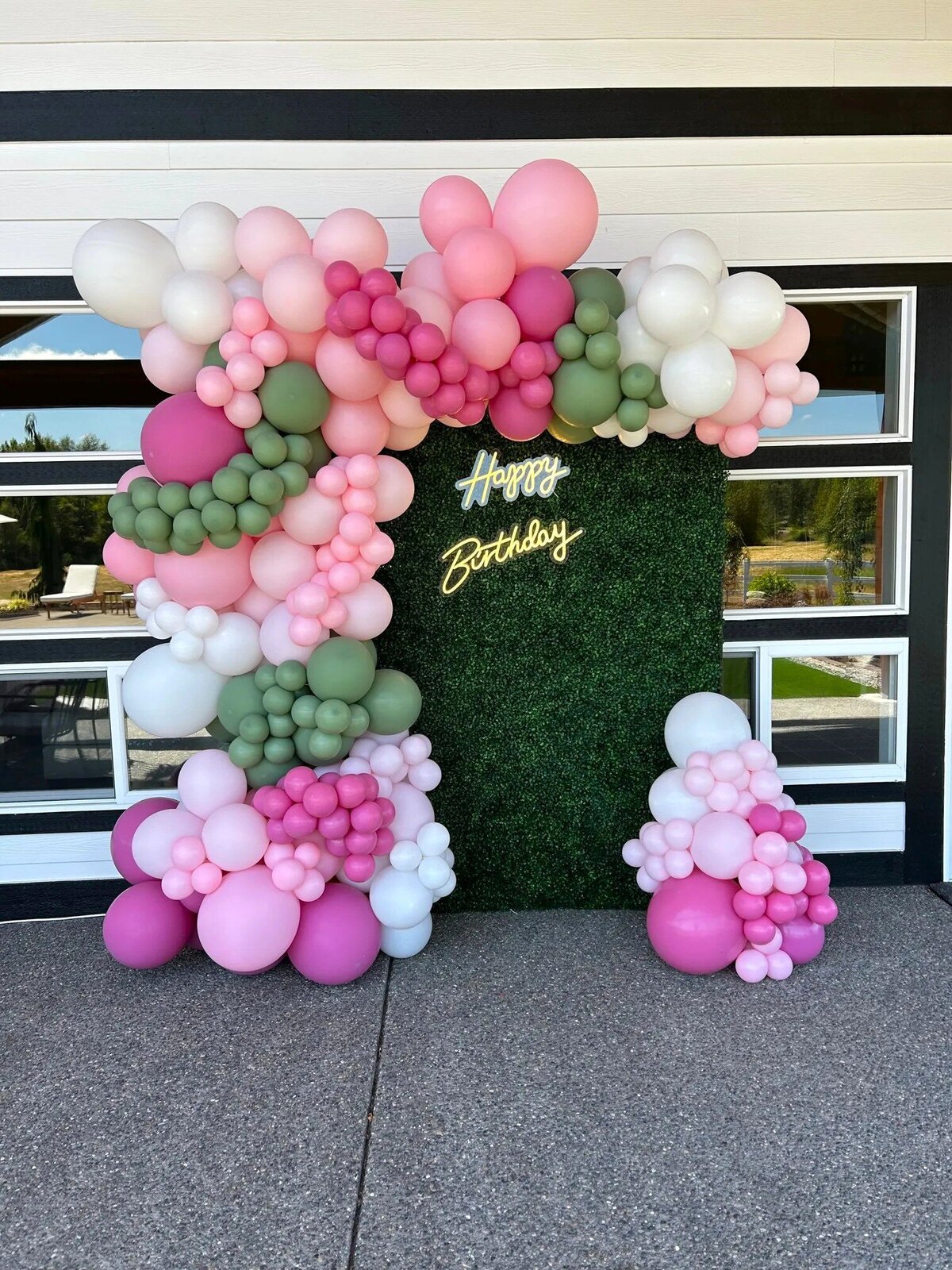 pink, green, and white happy birthday balloons with backdrop