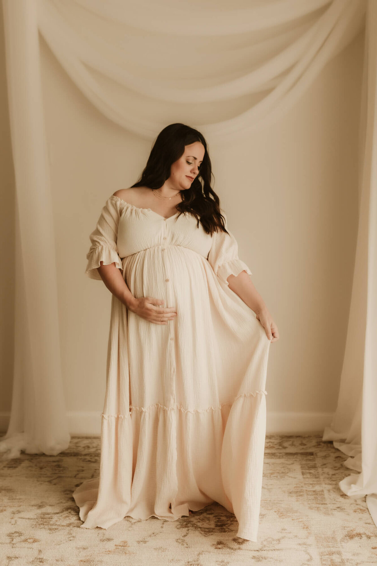 Maternity portrait of a mother holding her dress in OKC.