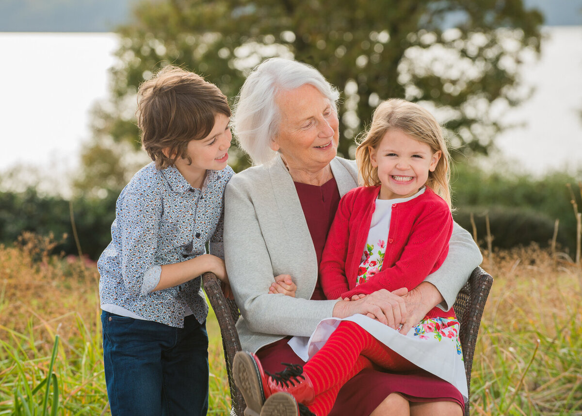 grandmother with grey hair having fun with her grandchildren outdoors