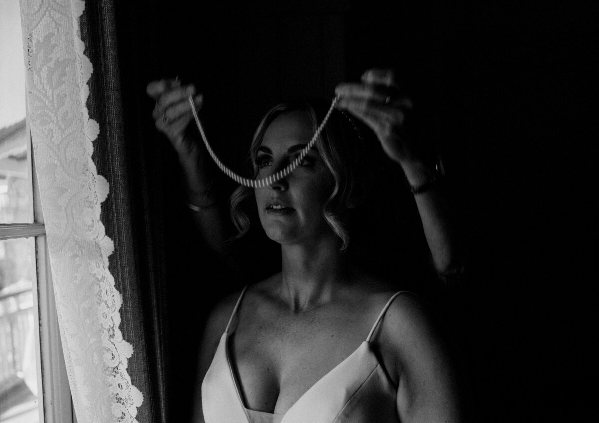 Bride's Mother putting on her pearl necklace