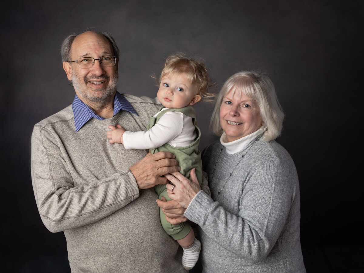 grandparents and grandson posing for studio portraits