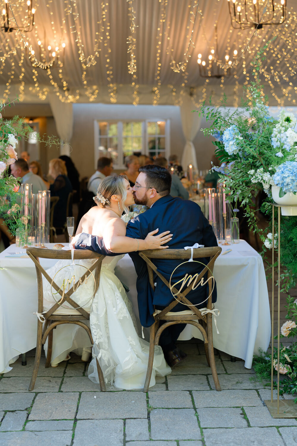 Bride and groom kissing at their sweetheart table