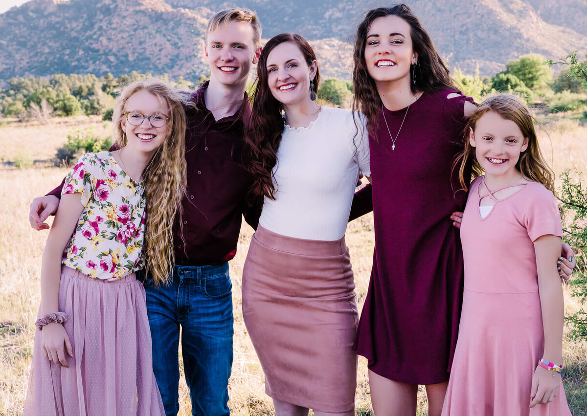 Siblings pose in front of mountain in Prescott family photos