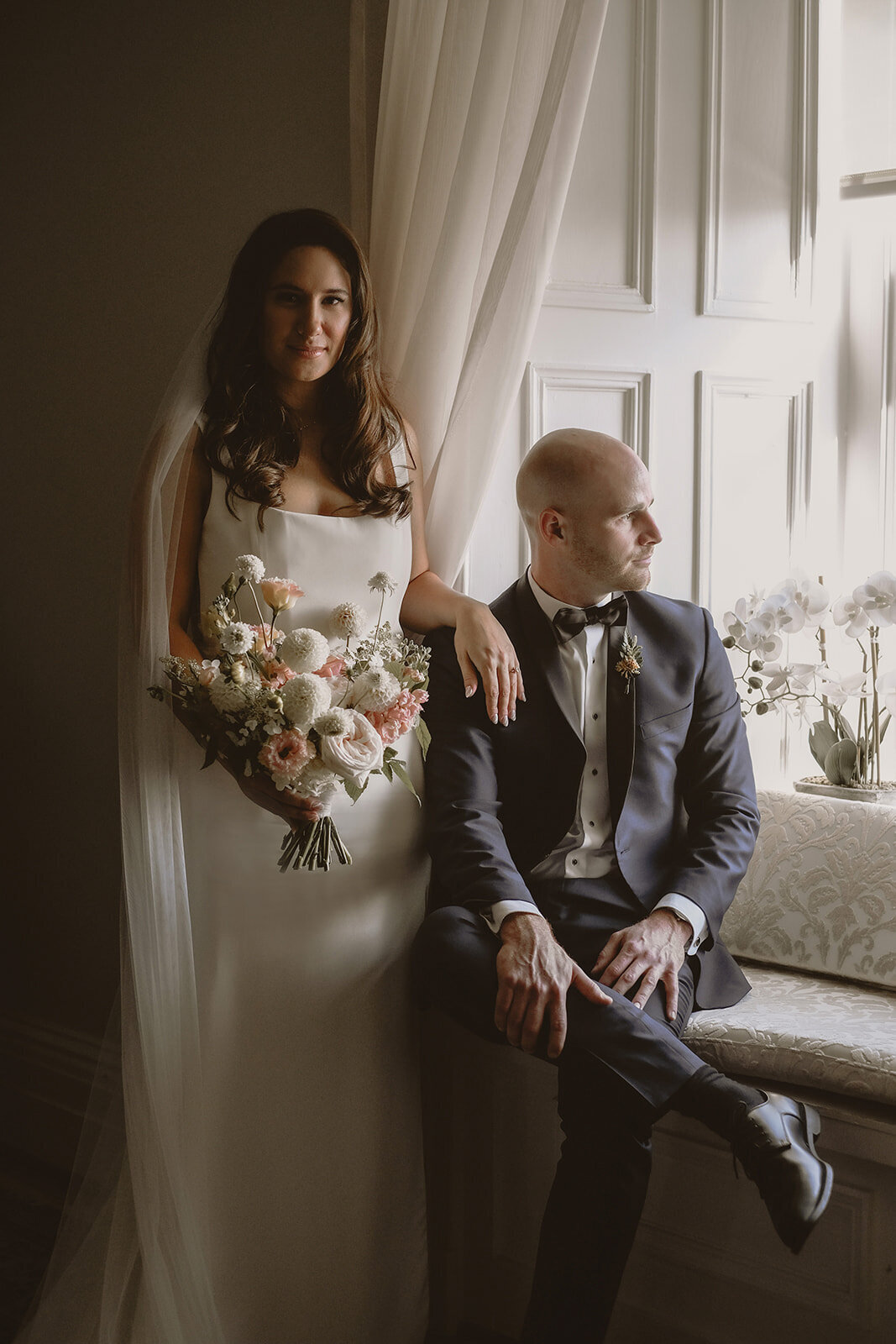 A couple pose in front of a picturesque open window at the Forest and Stream Club. 