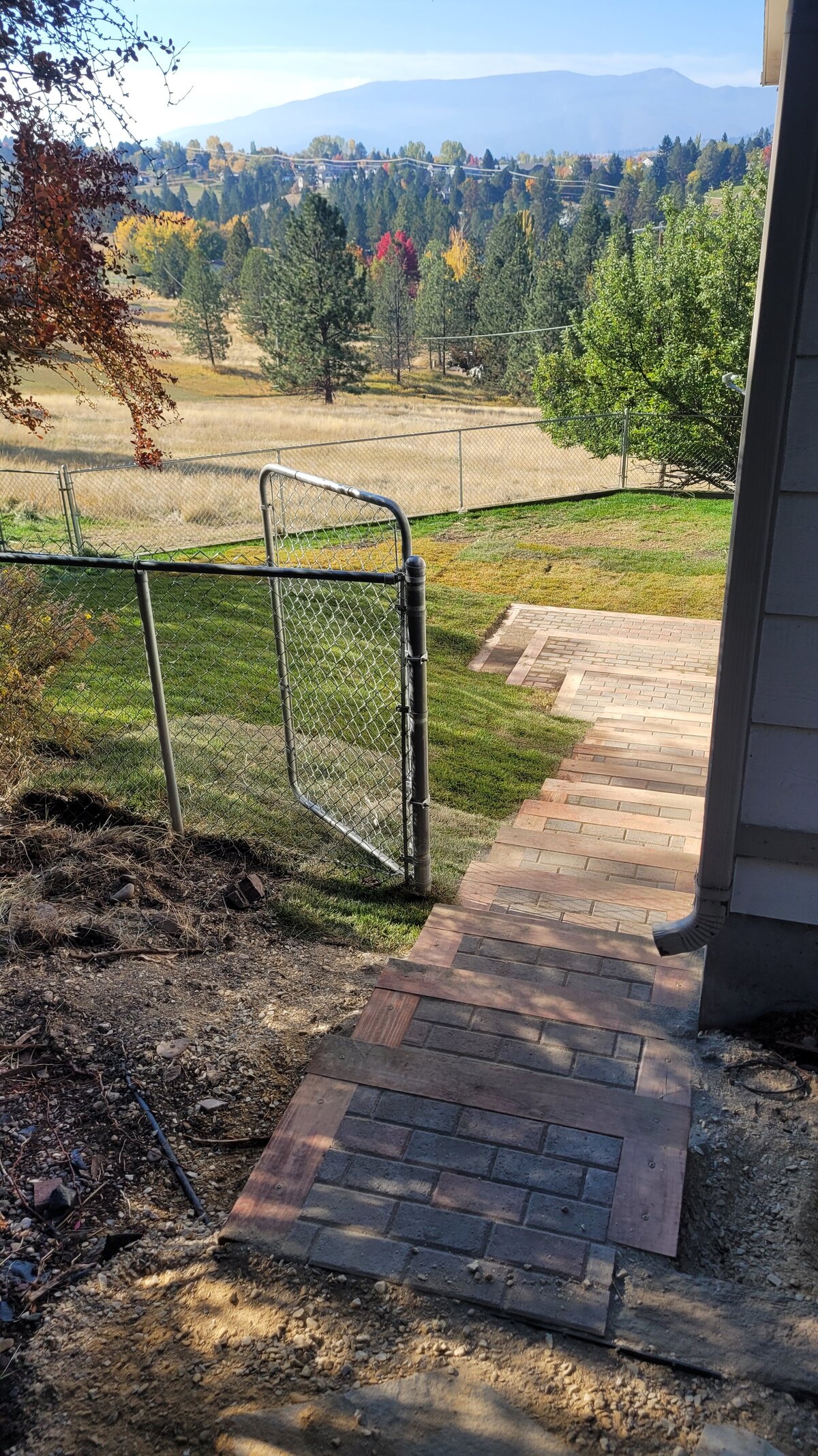 A brick walkway leads to a sunny backyard in Missoula, Montana.
