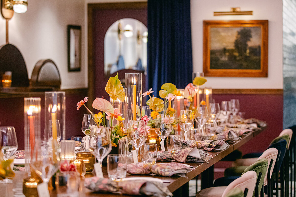 Intimate restaurant wedding dinner setup with lush florals, soft candlelight, and a warm ambiance