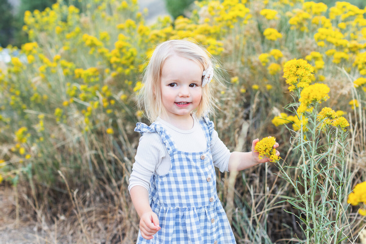 little girl holding flower for photo
