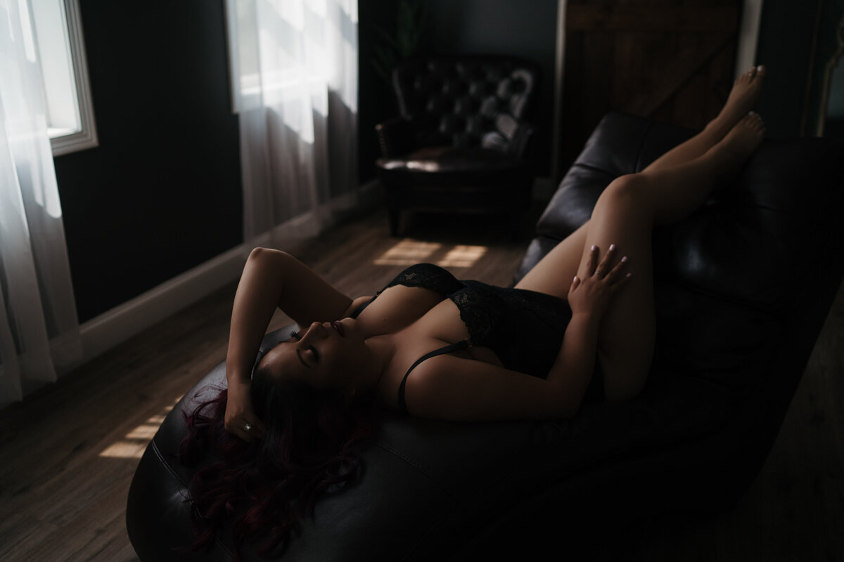 Woman in black lingerie on a chaise lounge