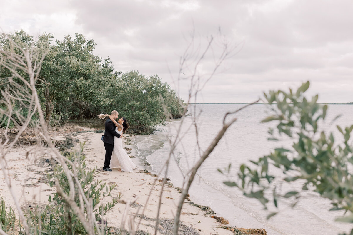 Bride and Groom celebrate their elopement on a Beach in Crystal River, Florida during sunset on a windy afternoon.