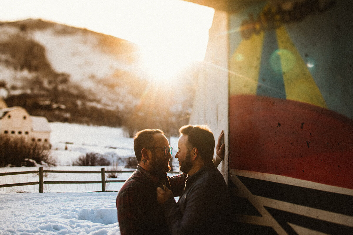 two men stand together with grafiti and sun flare 