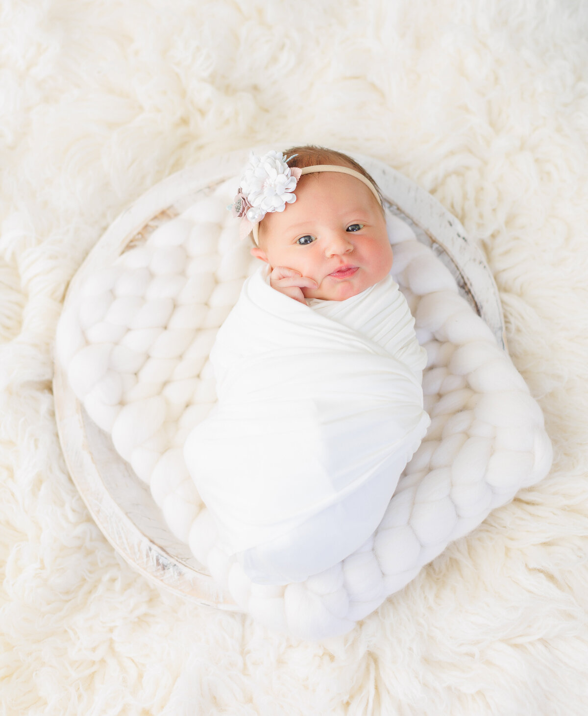 Newborn baby on a white bowl