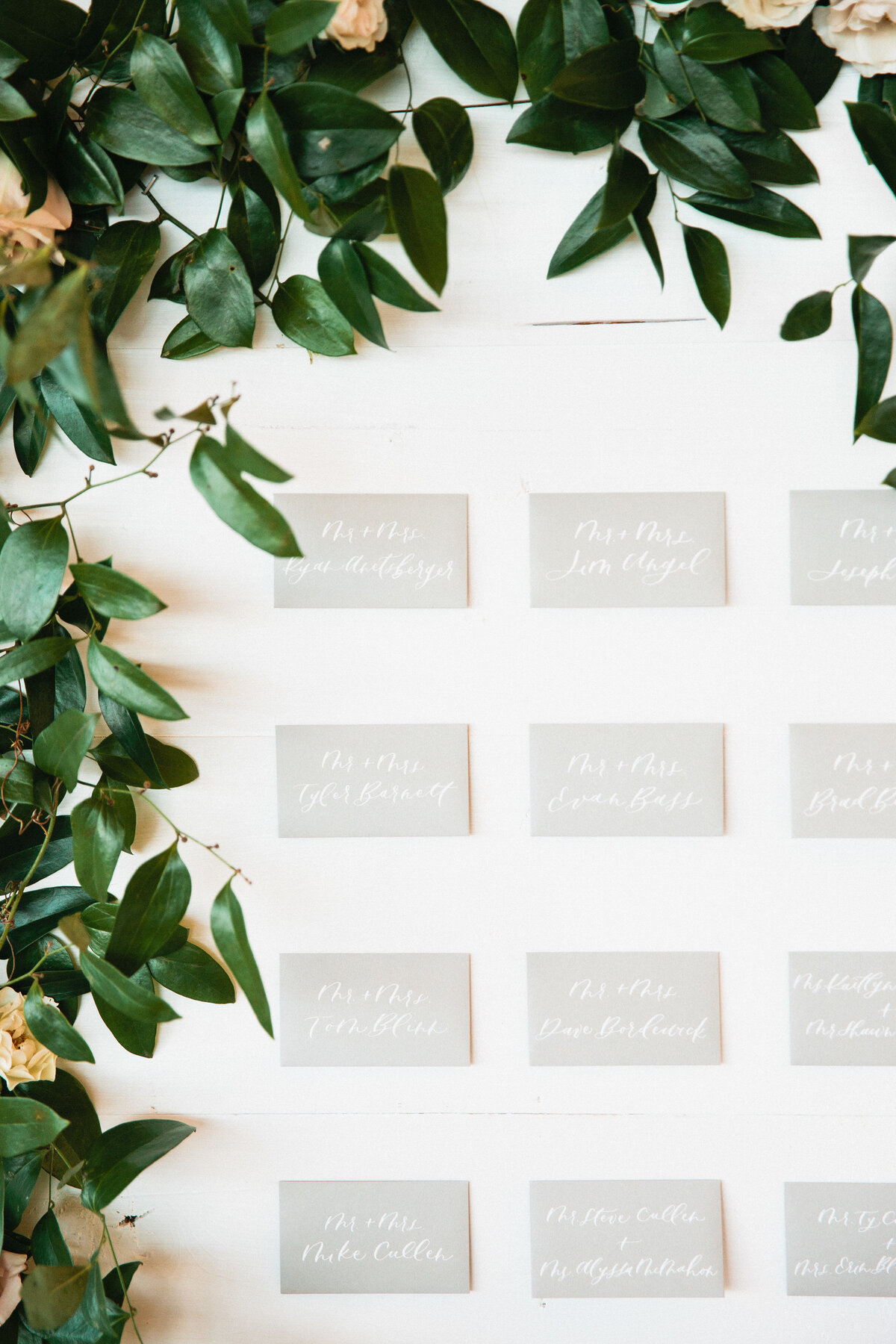 A gorgeous escort card wall and shiplap seating chart with a floral installation for Whitney Bischoff's Wedding
