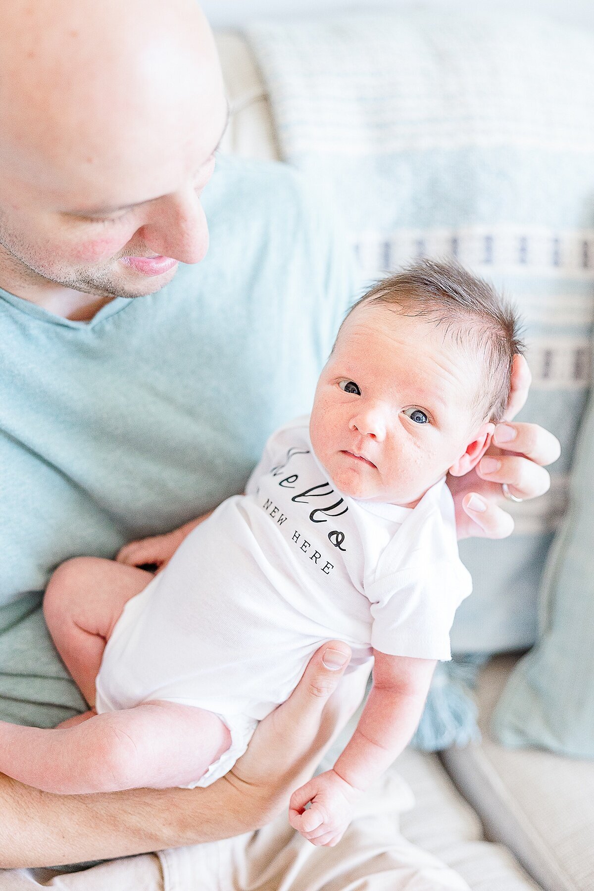 dad holds baby dung in-home newborn photo session with Sara Sniderman Photography in metro west Boston  Massachusetts